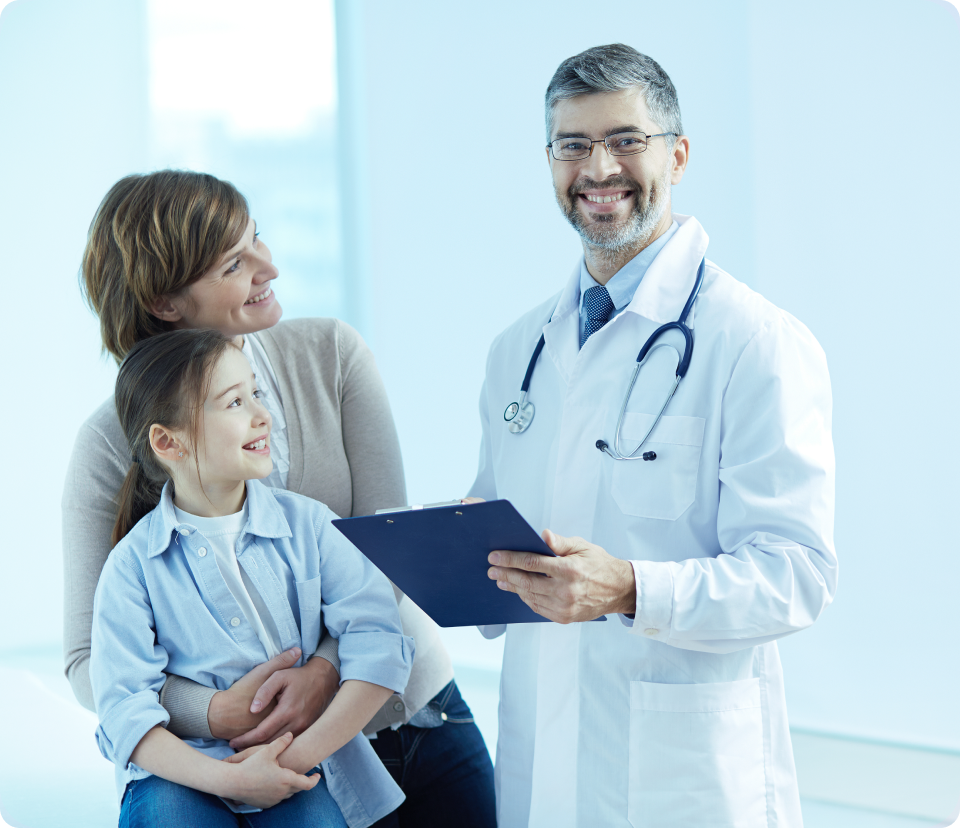 médico sorrindo ao lado de dois pacientes, uma mãe e uma filha.